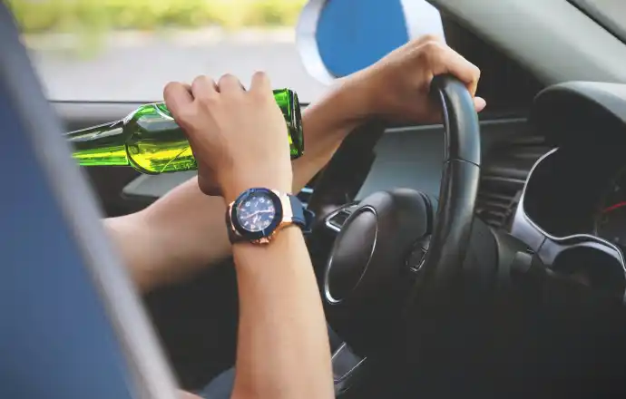 Man drinking alcohol inside his car